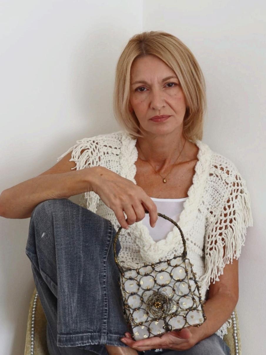Vlatka Omazić u bijelom pletivu, sjedi s Bella Mandorla torbom u krilu